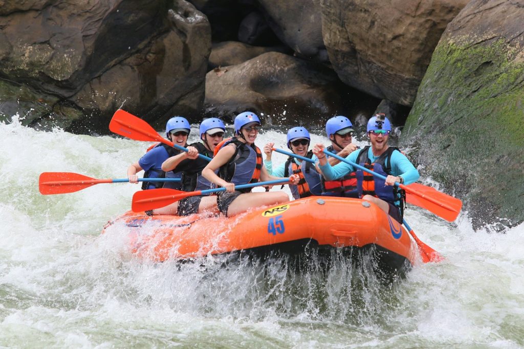 gruppo di colleghi sorridenti che fanno rafting