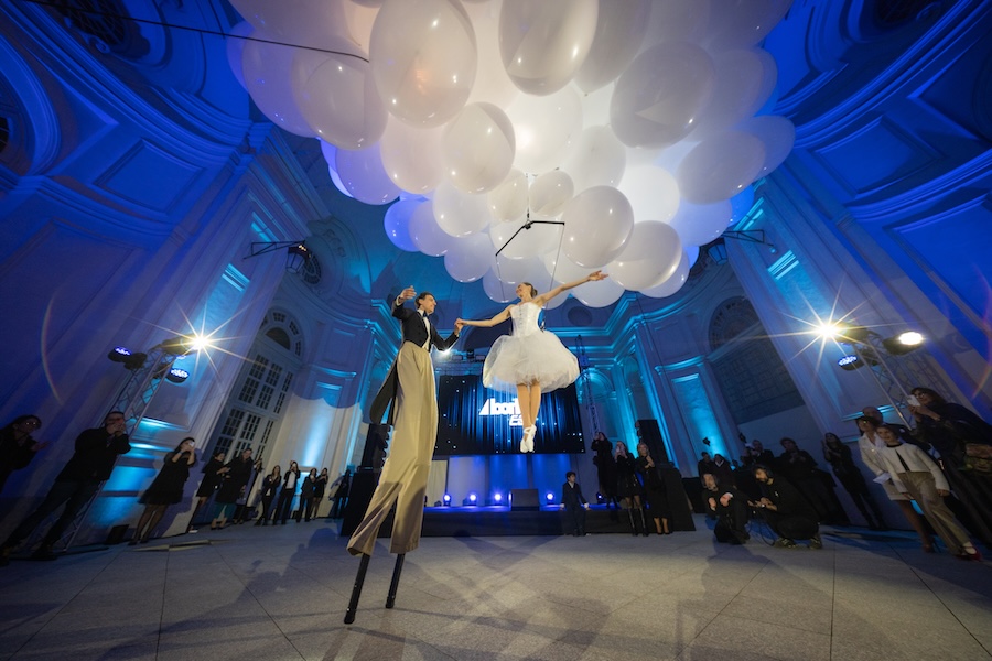 esibizione trampoliere e ballerina volante con palloncini davanti al palco dell'anniversario aziendale